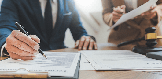 Image of a person signing legal documents for formal legal action